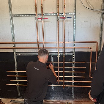 dyn yn gweithio ar y plymio gwresogi